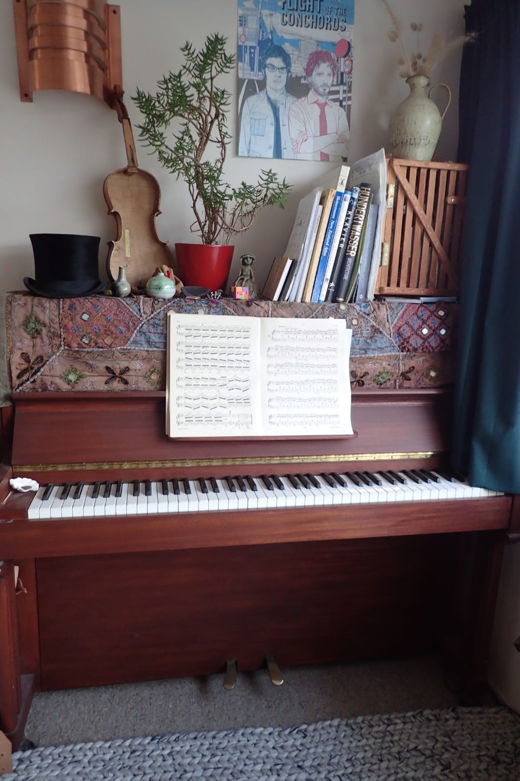 A piano with a music book and other objects on top
