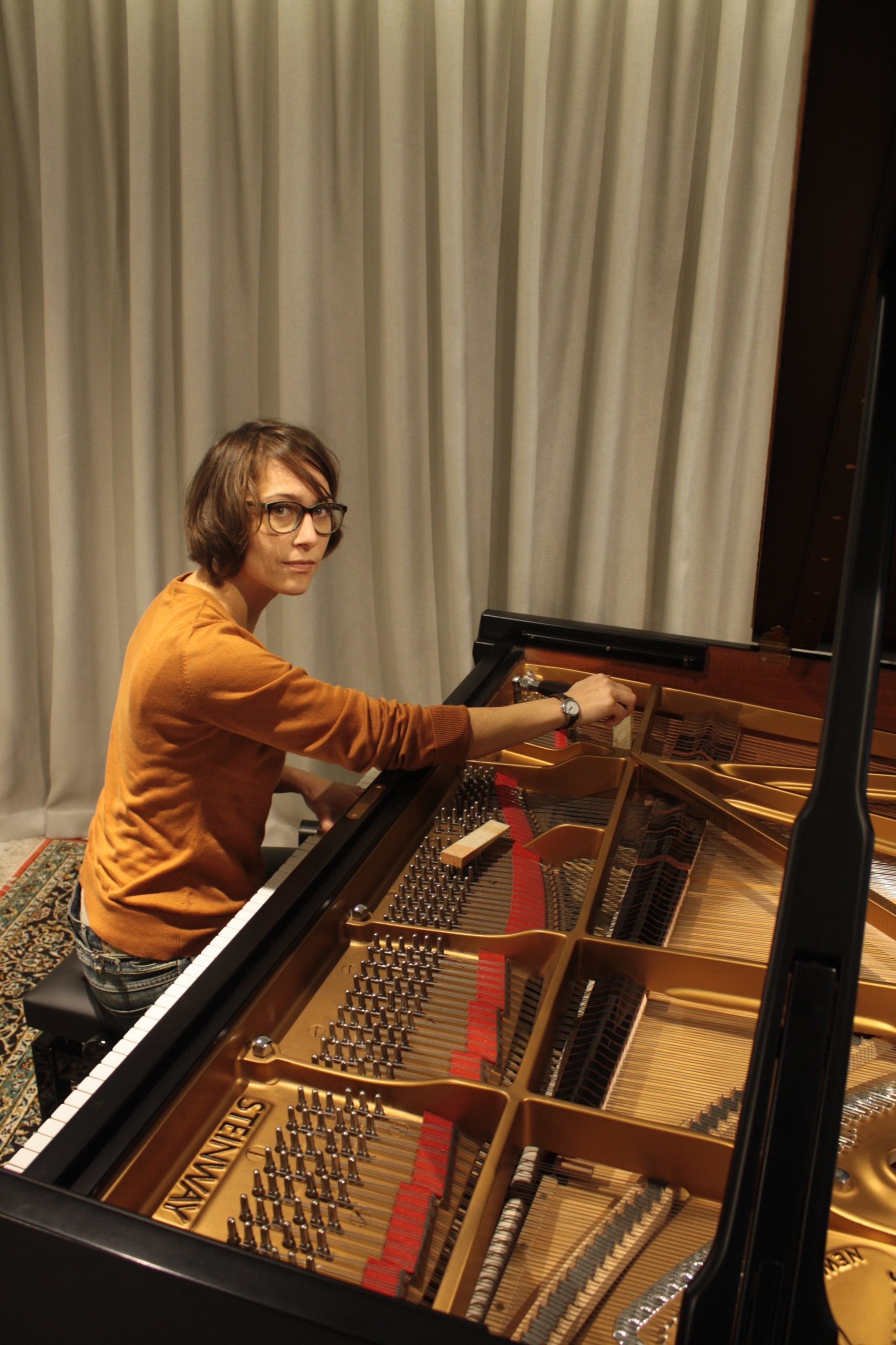 Christina tuning a grand piano